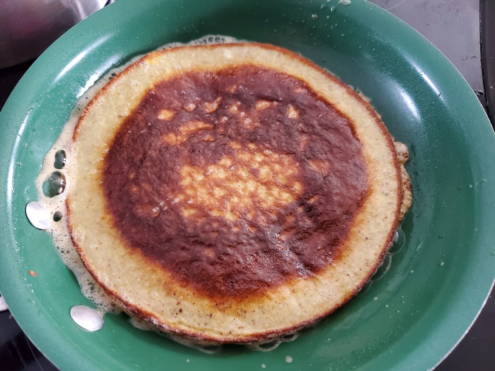 Eggcake having just been flipped over, showing nicely cooked side that looks just like a pancake.